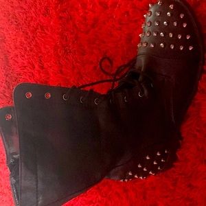 black combat boots with zip up on the side and silver spikes on the heel and toe